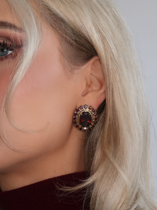 Close-up of model wearing Diana earrings with deep wine-coloured cubic zirconia in a vintage-style gold setting
