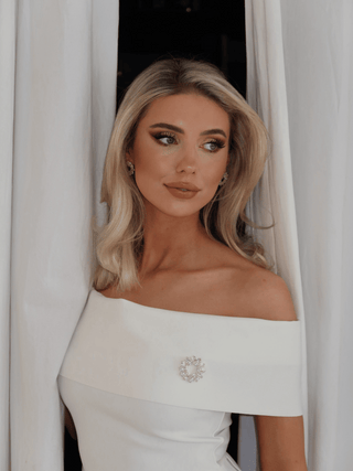 Model wearing Amanda Brooch in 14k gold plating with clear crystal cubic zirconia stones paired with matching Amanda Earrings