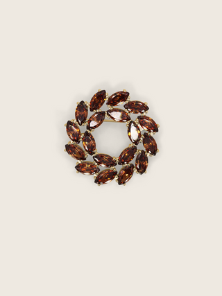 Gold plated silver brooch with marquise-cut brown stones in a circular wreath design on a neutral background