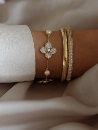 Christy pavé bangle in gold stacked with the classic Christy bangle and the multi midi Hydrangea bracelet featuring pearls and CZ floral detail