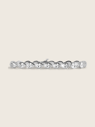 Constance pear tennis bracelet with white gold plating and a continuous row of clear pear-shaped cubic zirconia stones, elegant fine jewellery displayed on a white background.