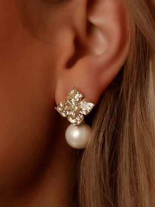 Close-up of Crystal Hydrangea earring in lemon with premium White Gold plating, featuring single-cut CZ petals and a shell pearl drop worn in model’s ear