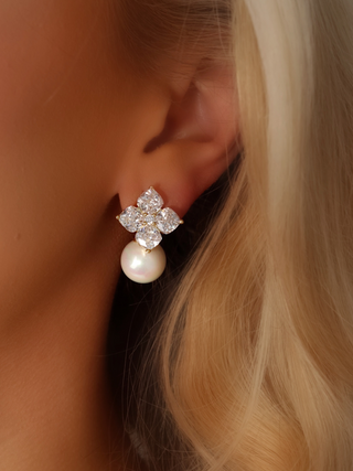 Close-up of a model wearing the Crystal Hydrangea Earrings with Shell Pearl, showing the radiant CZ floral top and the elegant shell pearl drop in a gold-plated sterling silver setting.