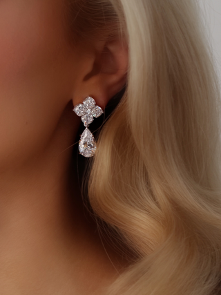 Close-up of a model wearing the Crystal Hydrangea Pear Drop Earrings, showcasing the delicate pear-shaped CZ drop and the detailed hydrangea top in a white gold-plated sterling silver setting.