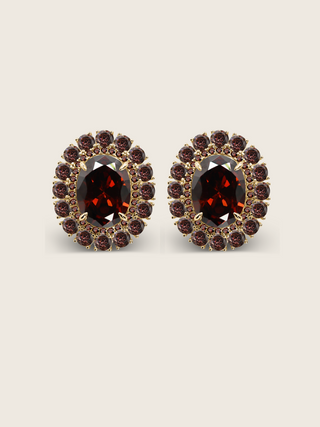 Diana earrings with wine cubic zirconia stones set in an oval gold frame, shown on a neutral background