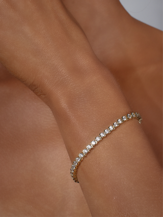Gold plated Estelle tennis bracelet with cubic zirconia stones, elegant S-link design on wrist
