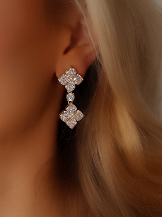 Gold plated double crystal hydrangea drop earring with clear CZ stones worn on model. Close-up of two-tier floral earring with elegant sparkle and graceful movement.