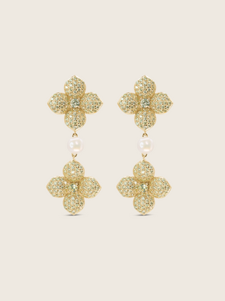 Gold plated hydrangea dangle earrings with yellow cubic zirconia stones and freshwater pearl on white background. Floral statement earrings with sparkling finish.