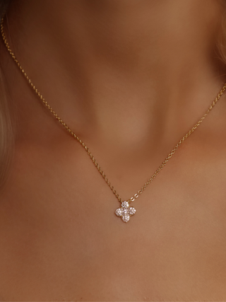 Mini gold hydrangea necklace in light pink CZ worn at the collarbone, a refined and feminine piece ideal for layering or everyday sparkle