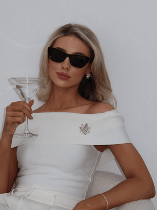 Model wearing Iris Brooch in 14k gold plating with clear marquise cut cubic zirconia stones on off shoulder dress paired with matching Iris Earrings