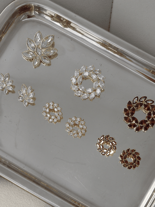 Iris Brooch in 14k gold plating with clear marquise cut cubic zirconia stones displayed on tray alongside Amanda Brooch, Iris Earrings and Amanda Earrings