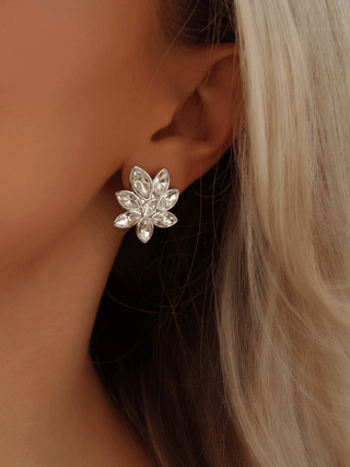Iris Earring in premium White Gold plating with clear crystal cubic zirconia stones in floral design, shown worn on ear close-up