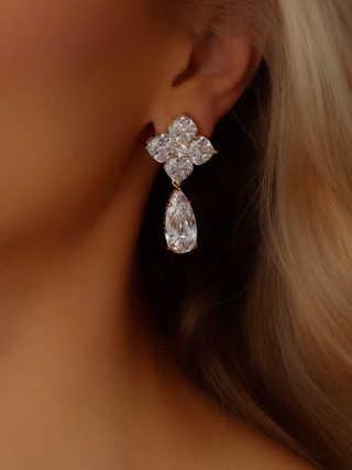 Close-up of a model wearing the Large Crystal Hydrangea Pear Drop Earrings, showcasing the bold pear-shaped CZ drop and the finely cut hydrangea top in a gold-plated sterling silver setting.