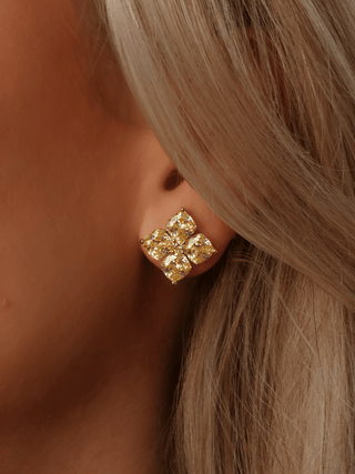Close-up of Lemon Drop gold crystal flower stud earring worn in ear on model, with radiant CZ petals