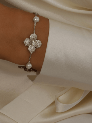 Lemon Drop Hydrangea bracelet in premium White Gold plating on model’s wrist, featuring lemon CZ floral centre and freshwater pearls on a delicate adjustable chain