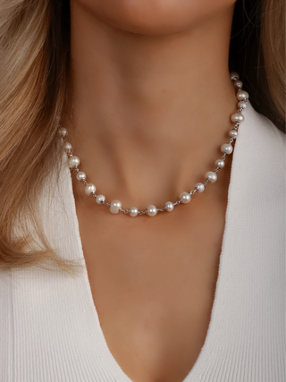 Close-up of White Gold-plated Margot pearl necklace with alternating freshwater pearls worn with white top