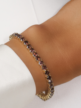 Maria Tennis Bracelet in 14k gold plating with brown cubic zirconia stones, shown on wrist close-up