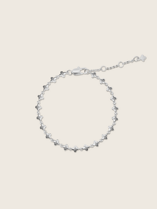 White gold plated micro hydrangea bracelet with adjustable chain displayed flat on white background