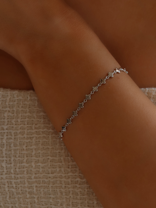 Model wearing white gold micro hydrangea bracelet with casual dress, showcasing chain on wrist