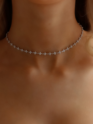 Micro hydrangea pavé necklace in white gold plated, worn on model’s neckline, highlighting the elegant design and sparkling details of the piece.
