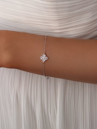 Close-up of the Mini Crystal Hydrangea Bracelet on a model’s wrist, paired with a white dress, showcasing the sparkle of the crystal hydrangea stones on a white gold-plated chain.