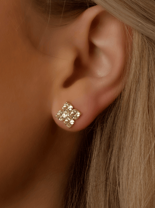 Close-up of model wearing mini Lemon Drop gold crystal flower stud earring, with 14k Gold plating and sparkling CZ petals