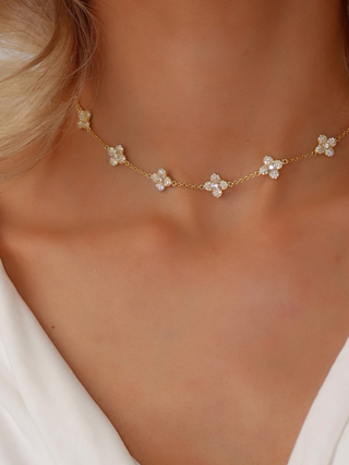 Multi Mini Hydrangea necklace in gold plating worn by model, showcasing a series of small pavé flower motifs across the neckline