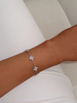Close-up of Multi Mini Hydrangea bracelet in White Gold plating worn on wrist, with floral pavé charms spaced along a fine chain