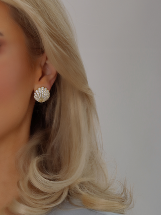 Model wearing Muriel pavé earrings with CZ stones in a 14k gold plated shell design