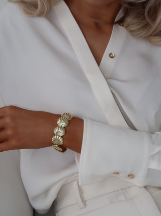 Muriel bracelet featuring linked shell motifs in 14k gold plating, worn on wrist