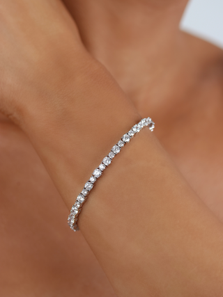Nova tennis bracelet premium white gold plated brass with continuous cubic zirconia stones shown close up on wrist