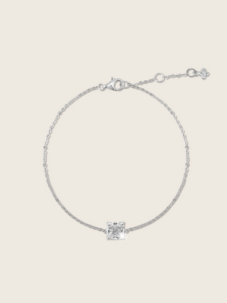 Regina bracelet featuring a minimalist square-cut CZ stone set on a delicate sterling silver and white gold plated chain, displayed flatly on a white background to showcase its refined contemporary design.
