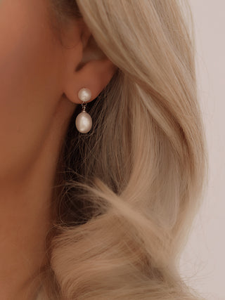 White gold stud drop earrings with two stacked freshwater pearls, polished finish and minimal design worn on model
