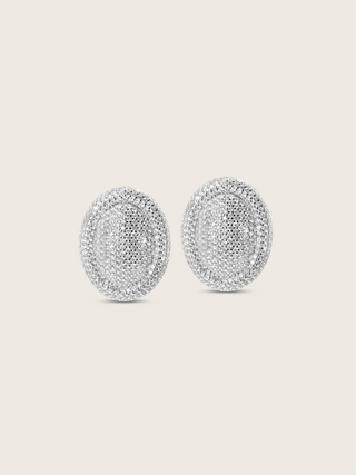 White gold plated Gigi pavé oval stud earrings fully covered in clear CZ stones, shown on white background. Statement earrings with all-over sparkle and curved silhouette.
