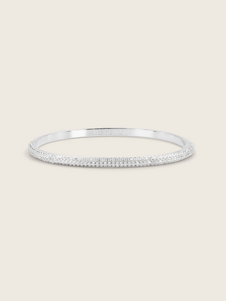White gold plated pavé slim Christy bangle on white background. Slim half-set CZ bracelet with subtle sparkle, perfect for stacking.