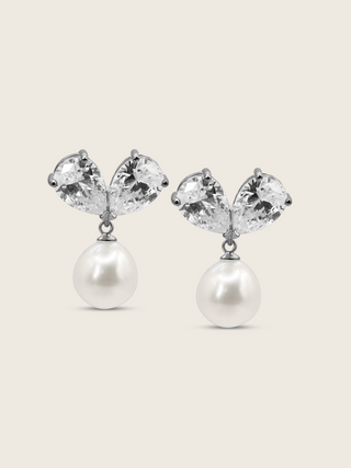 The Adore Earrings featuring two clear pear-cut CZ stones and a single freshwater pearl, set in sterling silver with white gold plating, displayed against a clean white background.