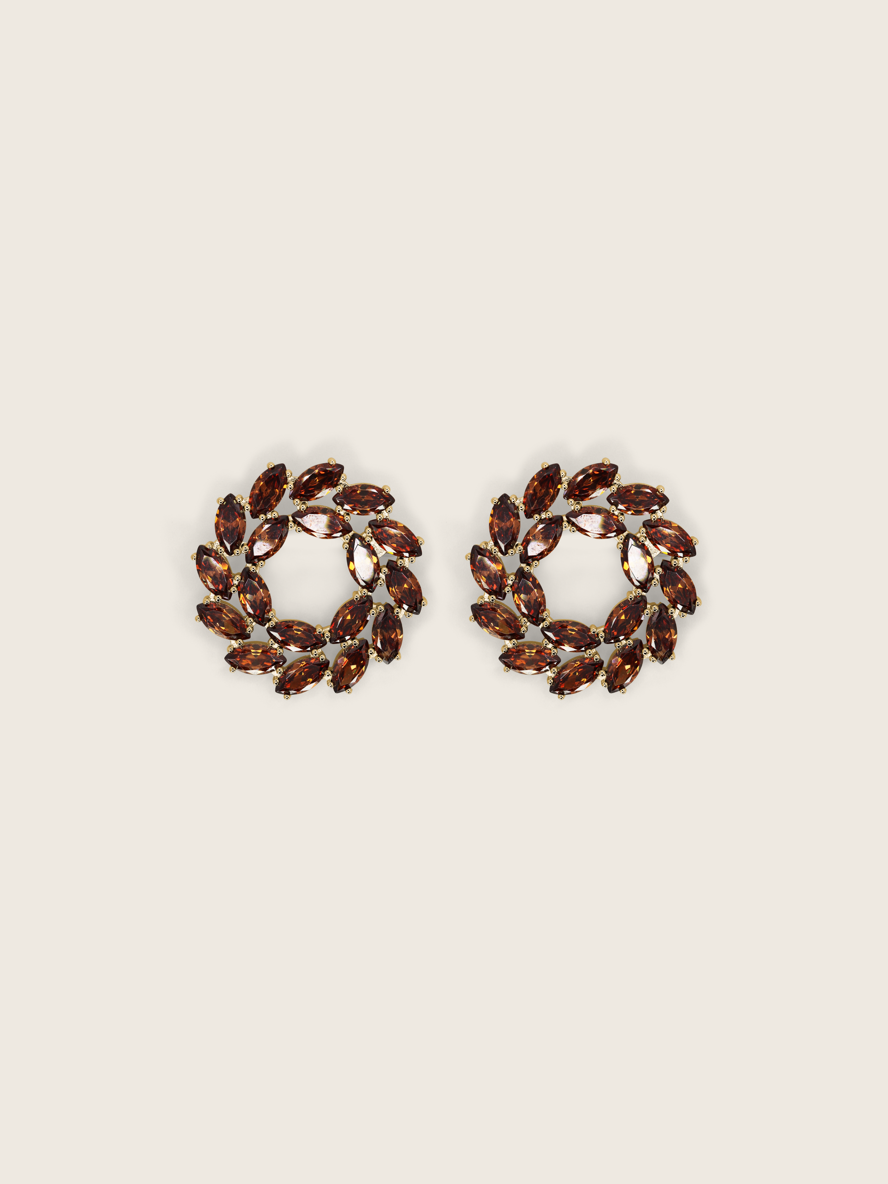 Gold plated stud earrings with brown marquise and round-cut stones in a wreath-style circular design on a neutral background