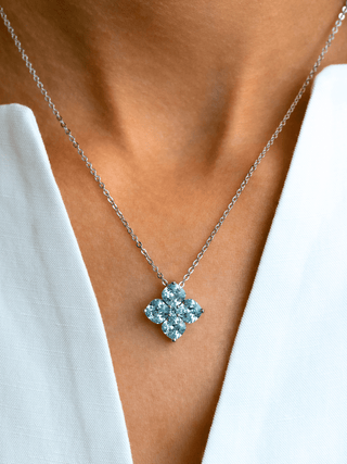 Close up of model wearing aqua crystal hydrangea necklace in white gold plating