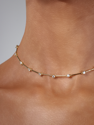 Close up of Astra necklace in gold plating with cubic zirconia stars, styled on neckline