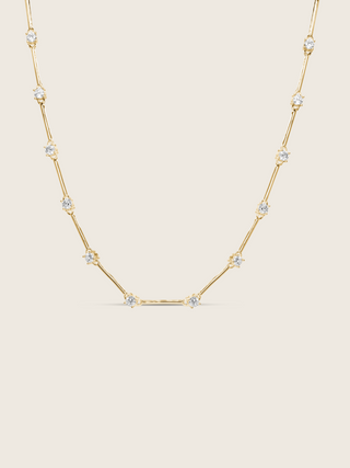 Gold plated Astra necklace with cubic zirconia star details, flat lay on white background