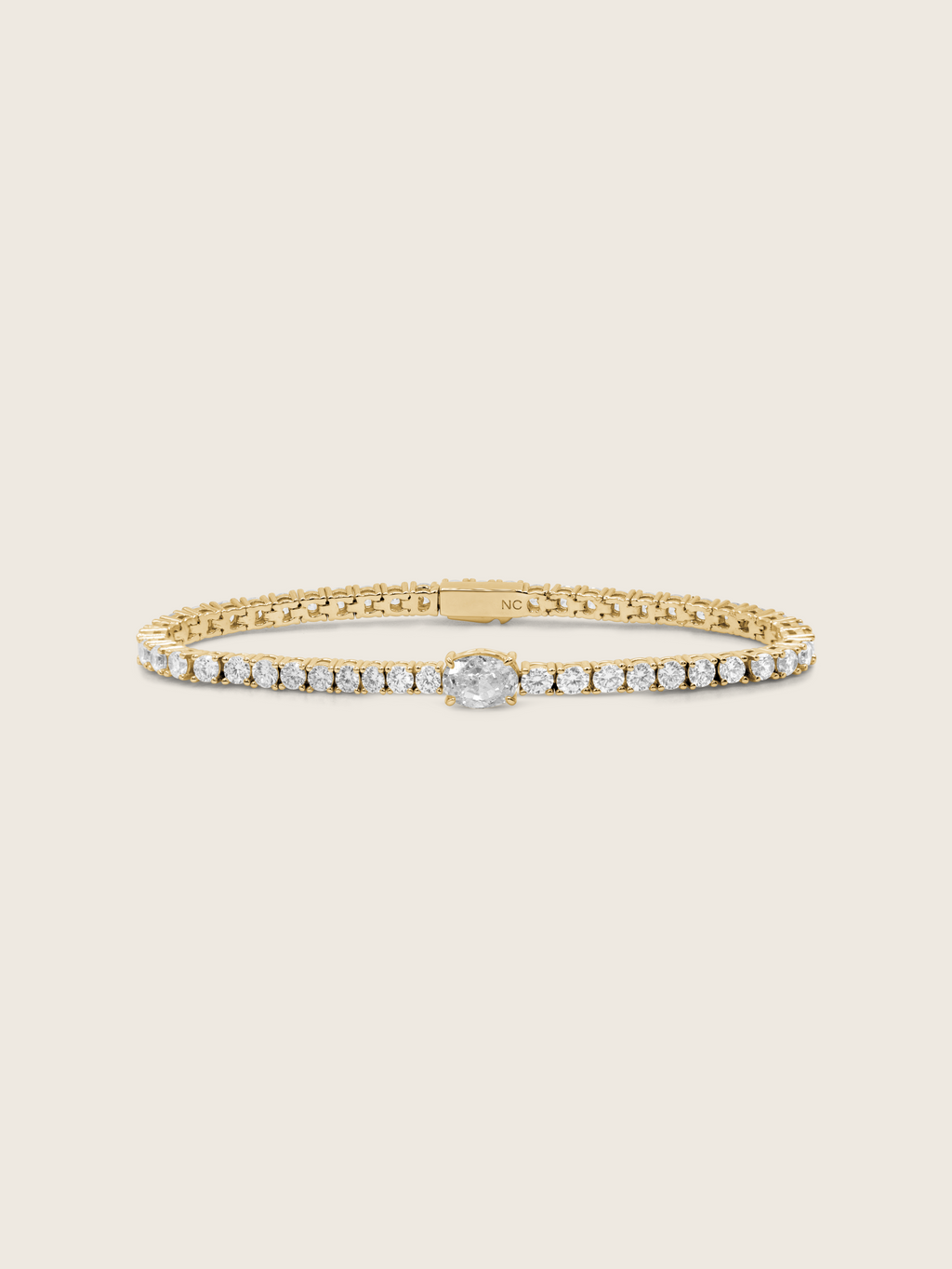 Aurelia 14k gold plated tennis bracelet with central oval clear CZ stone and classic flatlay on neutral background