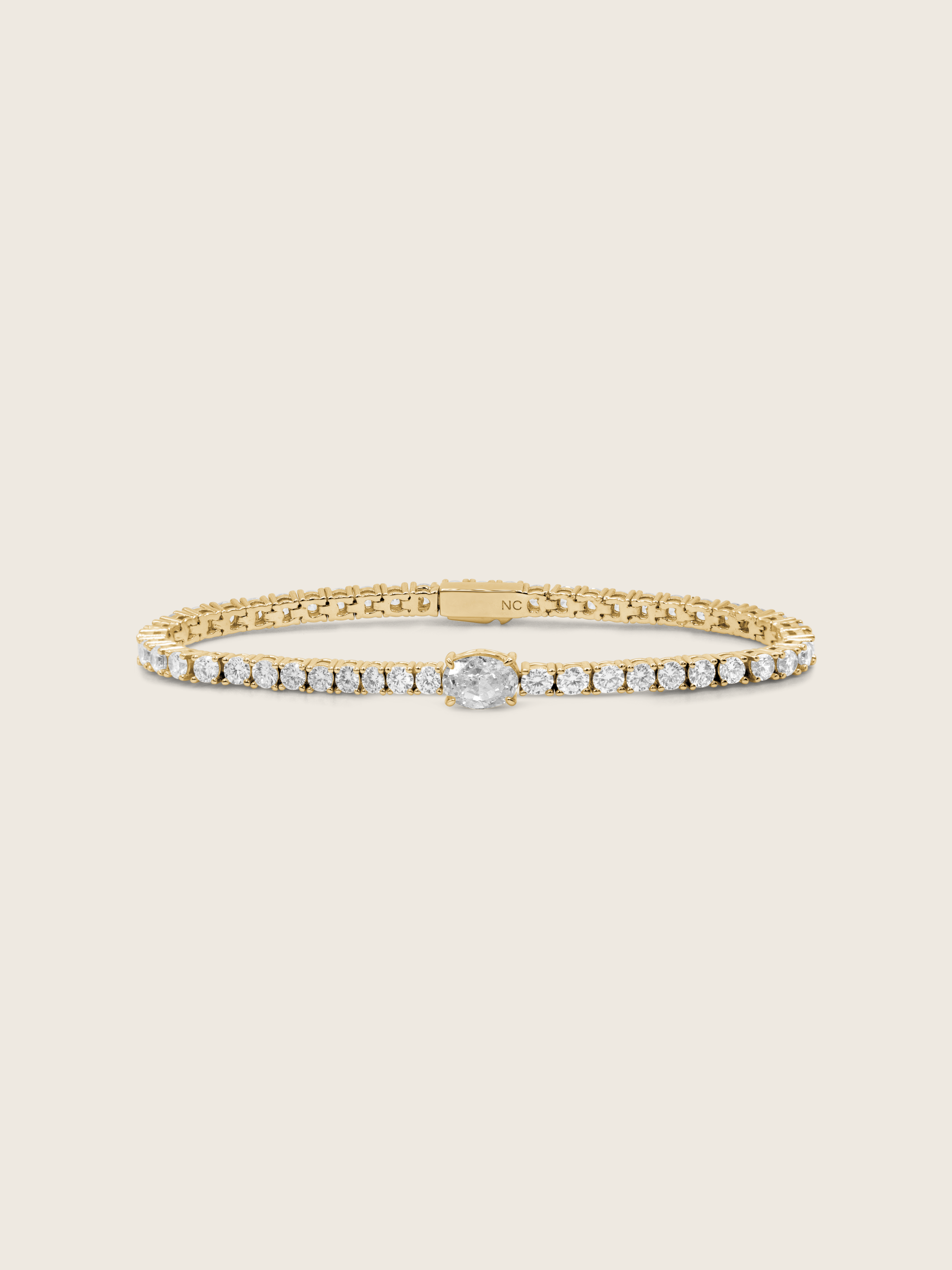 Aurelia 14k gold plated tennis bracelet with central oval clear CZ stone and classic flatlay on neutral background