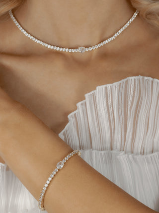 Gold plated tennis bracelet with central oval clear CZ stone, styled with matching gold Aurelia necklace on model