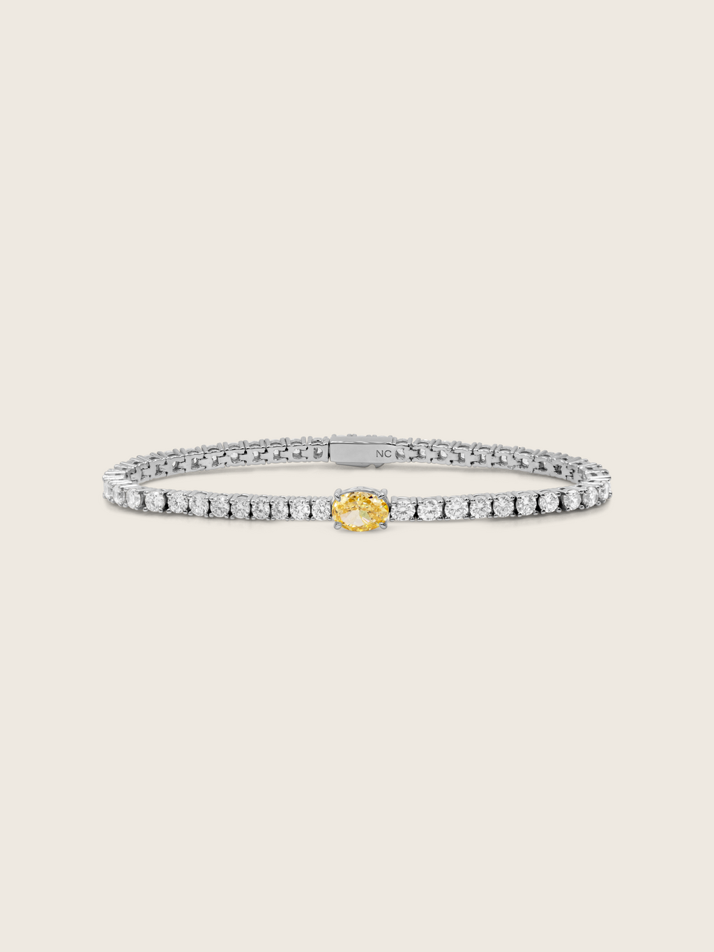 Gold tennis bracelet with central lemon yellow oval CZ stone and clear CZ detailing throughout