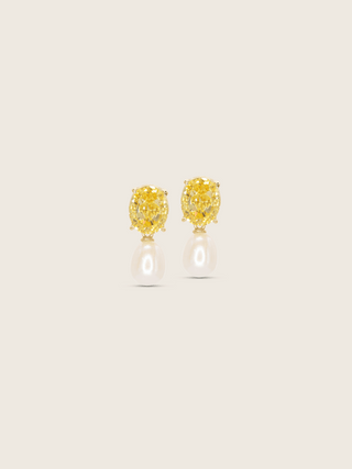 Gold plated Aurelia earrings with oval lemon yellow CZ stones and freshwater pearl drops on neutral background