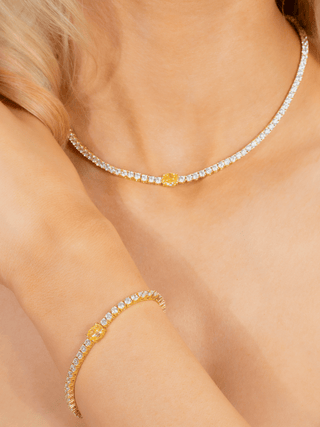 Model wearing matching Aurelia lemon drop tennis bracelet and necklace in gold plating, featuring yellow oval centre CZ stones and clear crystal accents