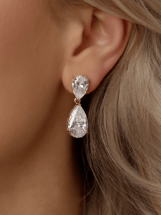 Close-up of a model wearing a pair of aurora teardrop-shaped cubic zirconia earrings.