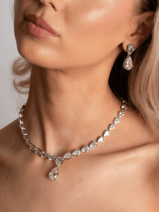 Model wearing Aurora Necklace and Earrings in premium white gold plating with pear shaped cubic zirconia, statement jewellery set styled for occasion wear