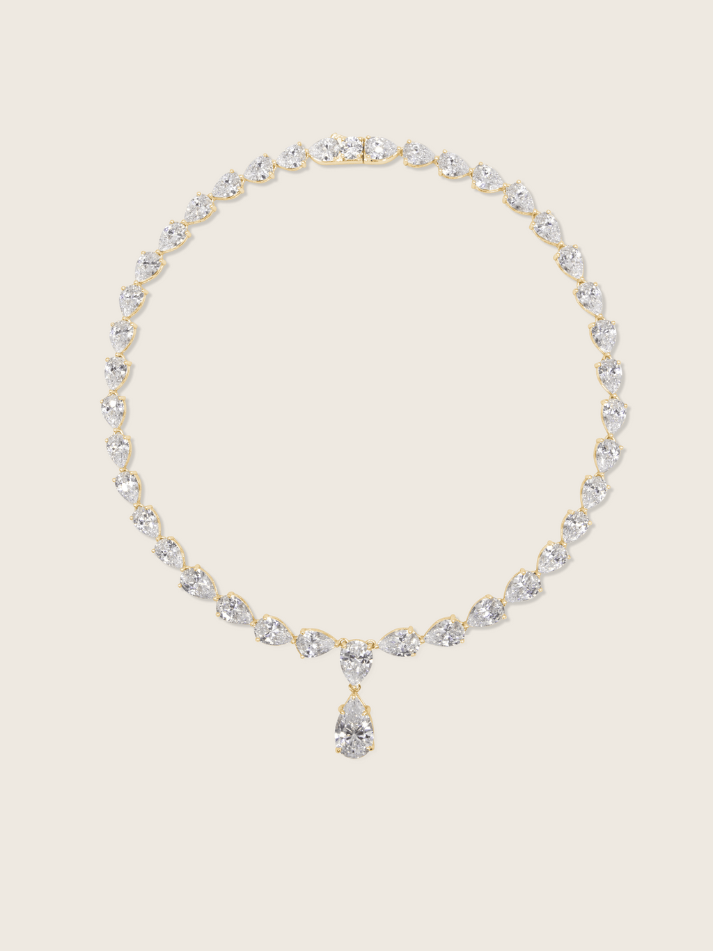 Flatlay of the Aurora Necklace with pear shaped cubic zirconia stones on a fine 14k gold plated chain, displayed on a neutral background