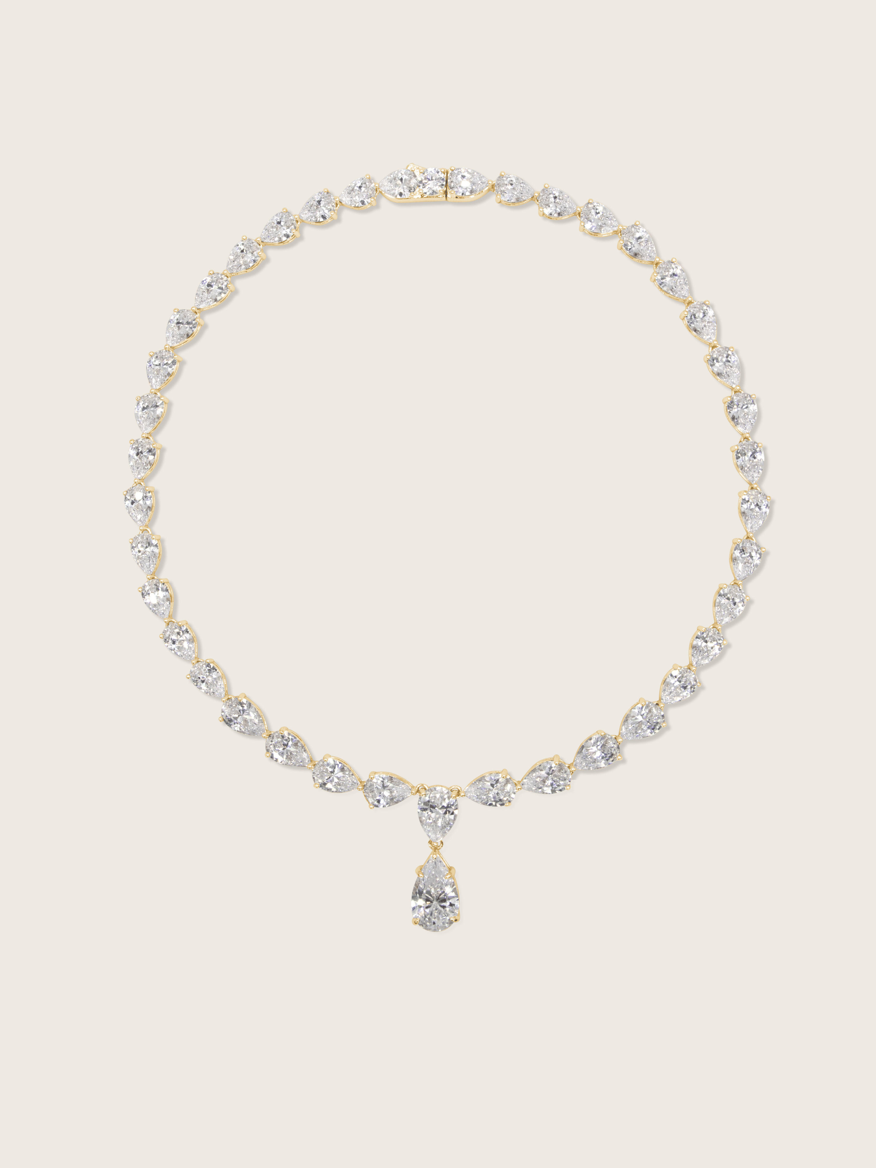 Flatlay of the Aurora Necklace with pear shaped cubic zirconia stones on a fine 14k gold plated chain, displayed on a neutral background